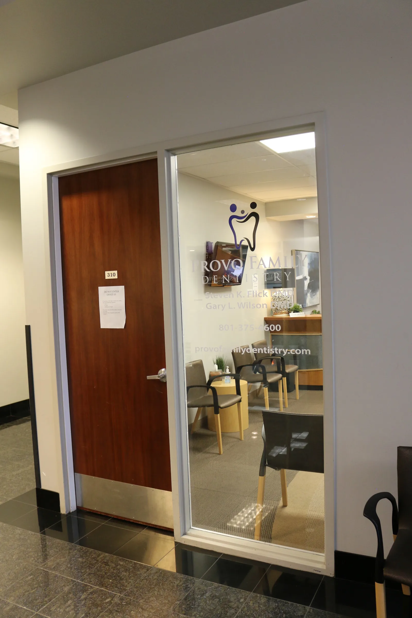 Entrance to office 310 with a glass window displaying Provo Family Dentistry lettering and the waiting area inside.